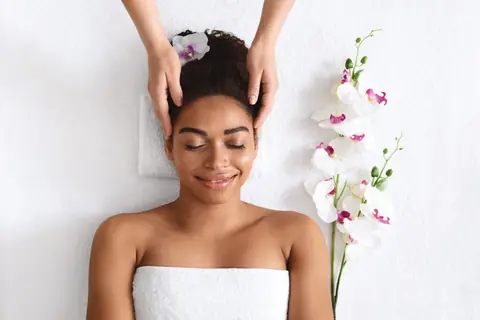 Top view of a joyful woman getting a head massage